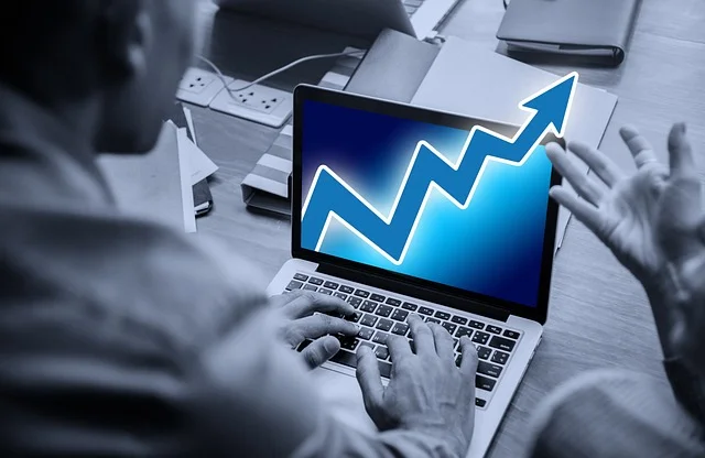 A man focused on a laptop featuring an upward arrow, representing investment growth in 5starsstocks.com passive stocks